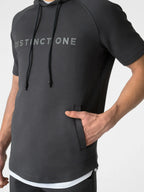 A close-up of a man wearing a dark gray short-sleeve athletic hoodie with 'DISTINCTONE' printed in light gray across the chest. The hoodie features black drawstrings and a side pocket with a tab closure, shown against a plain light gray background.