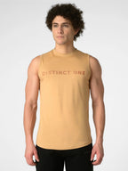 A man wearing a sleeveless tan athletic tank top with 'DISTINCT ONE' printed across the chest in a darker tan, paired with black pants, against a light gray studio background.