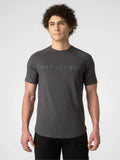A man wearing a dark gray short-sleeve athletic t-shirt with 'DISTINCT ONE' printed across the chest, paired with black pants, against a light gray studio background.