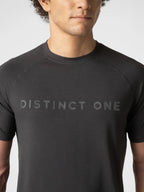 A close-up of a man wearing a dark charcoal gray short-sleeve athletic t-shirt with the words 'DISTINCT ONE' printed across the chest in a matching dark gray tone.