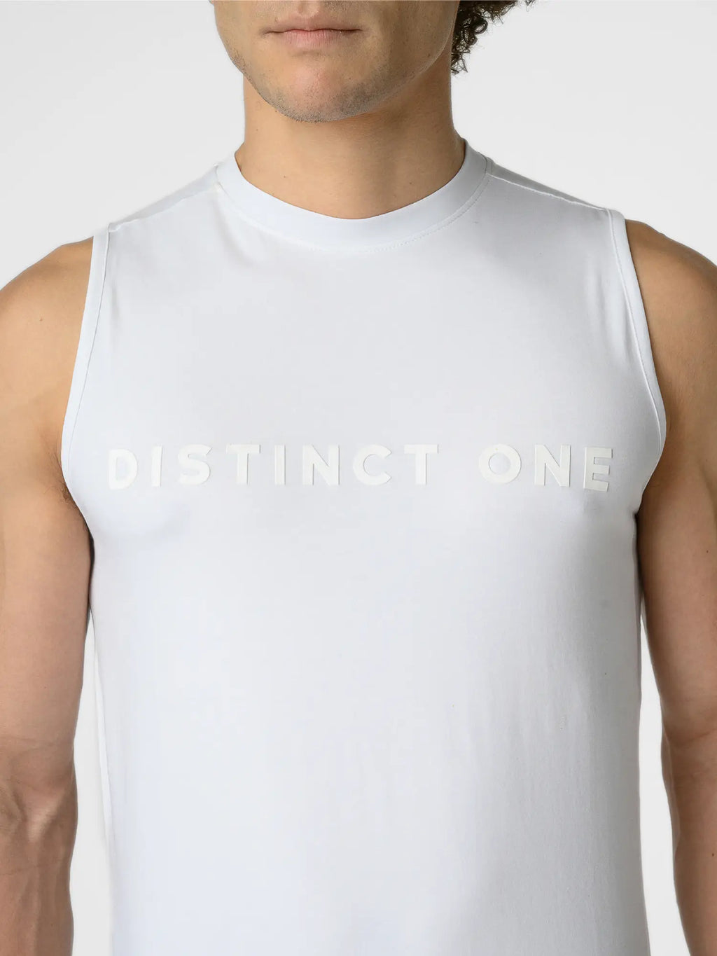 A close-up of a man wearing a white sleeveless athletic tank top with 'DISTINCT ONE' printed across the chest in a matching light tone.