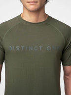 A close-up of a man wearing an olive green athletic t-shirt with the words 'DISTINCT ONE' printed across the chest in a matching dark gray tone.